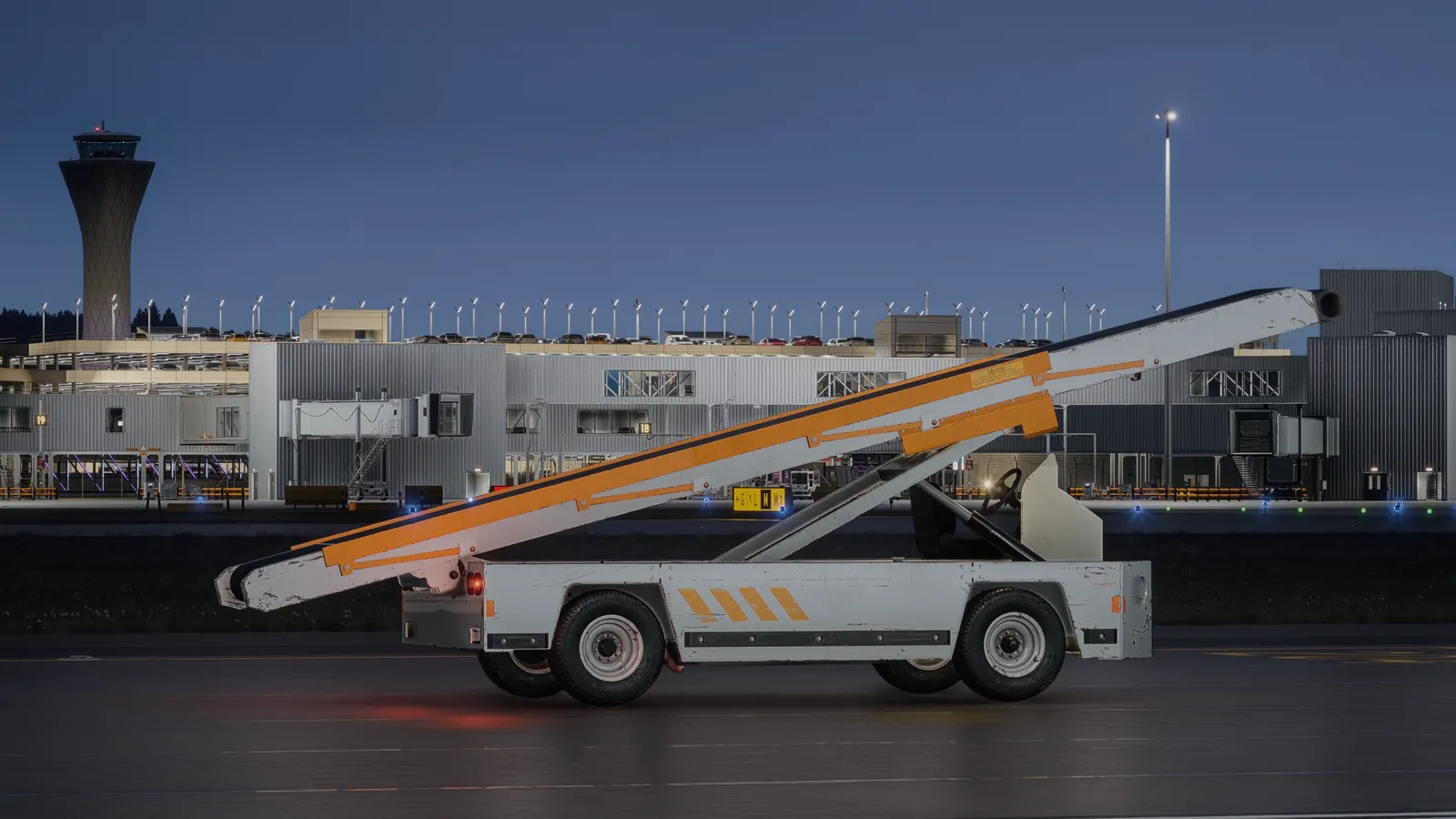 TUG 660 belt loader on the apron at night in front of the terminal