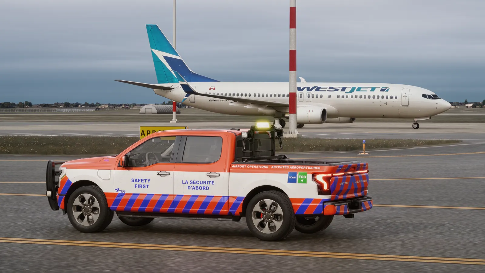 Airport operations pickup holding short of an apron while a WestJet 737 taxis past